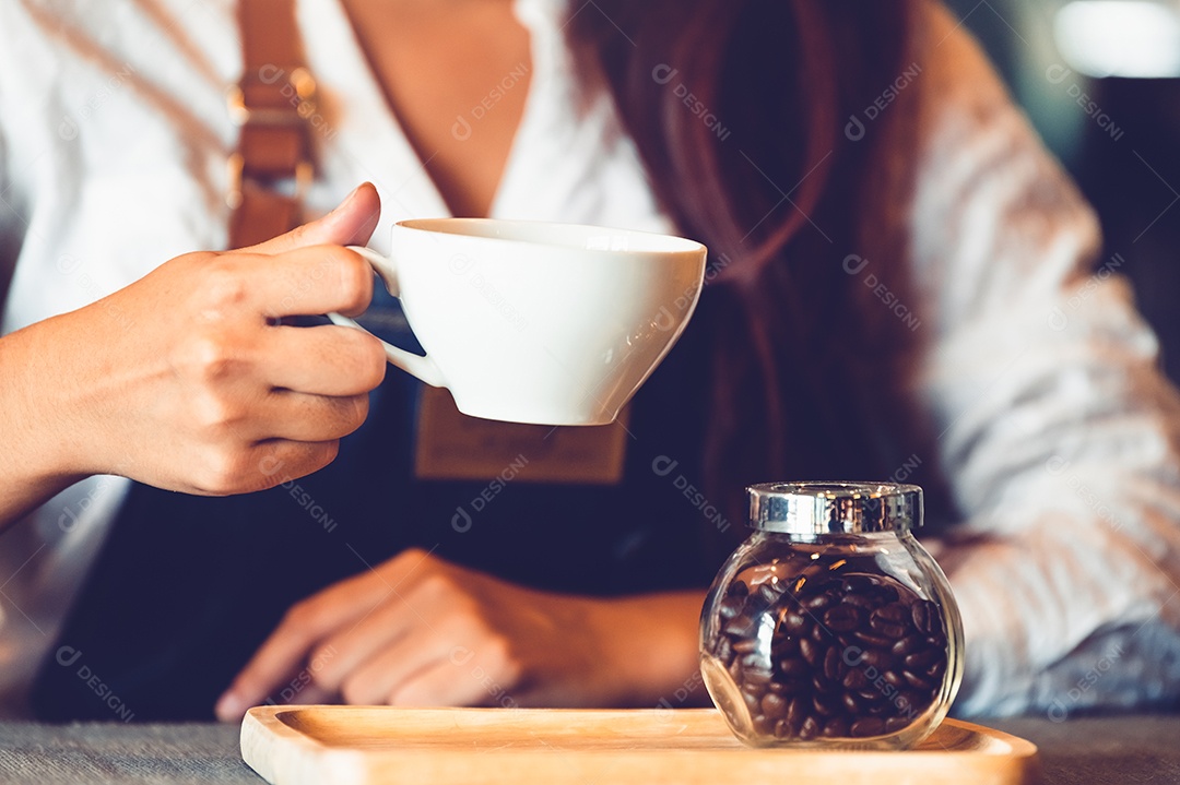 Aproximação da mão de barista feminina profissional fazendo e segurando.