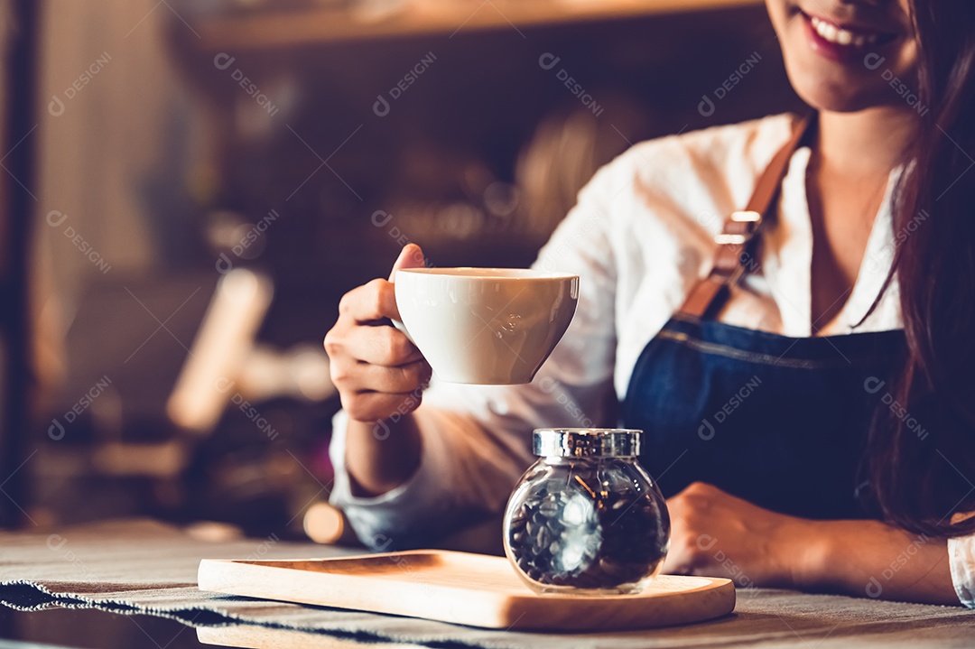 Aproximação da mão de barista feminina profissional fazendo e segurando café.