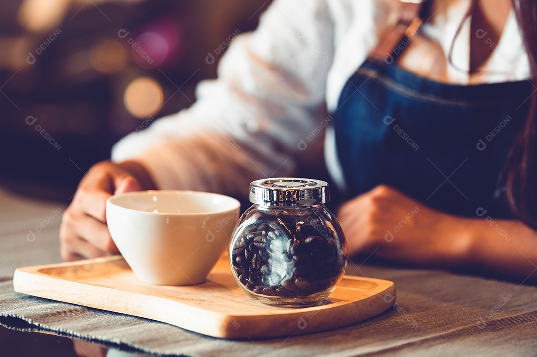 Aproximação da mão de barista feminina profissional fazendo e segurando café.