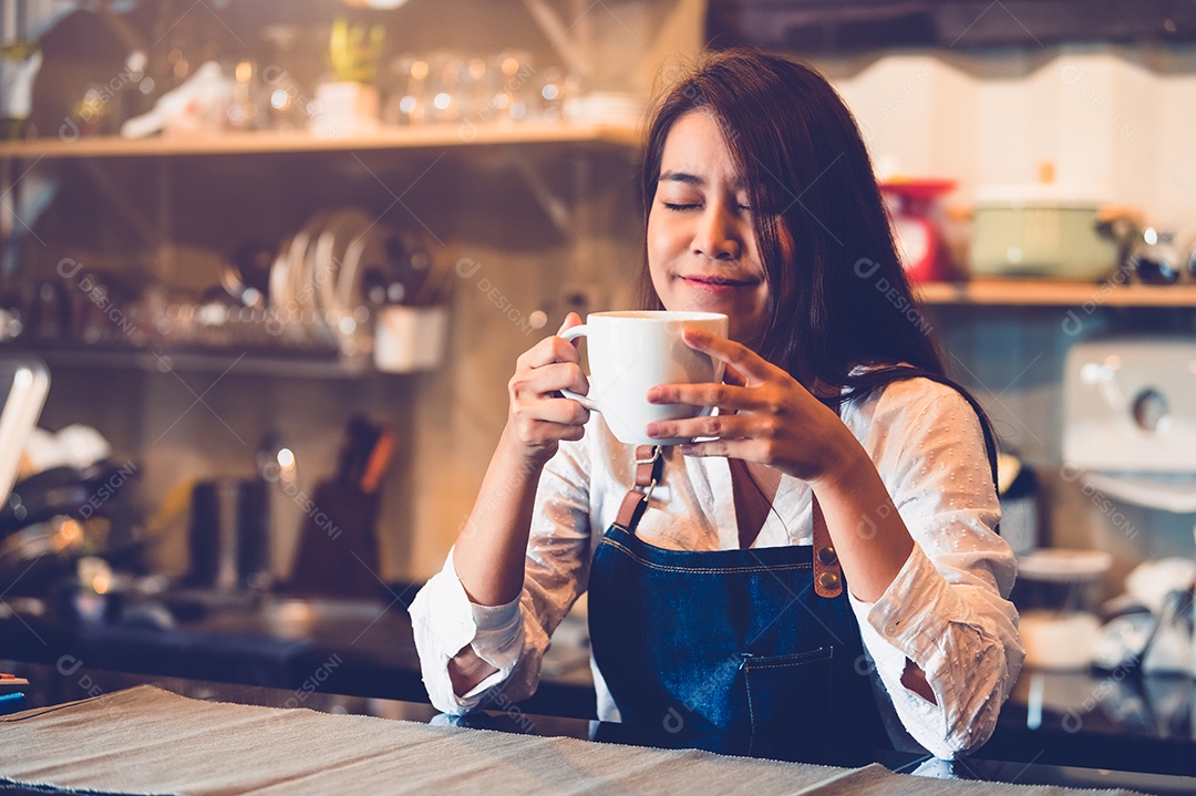 Beleza barista feminina asiática segurando a xícara de café e degustação.