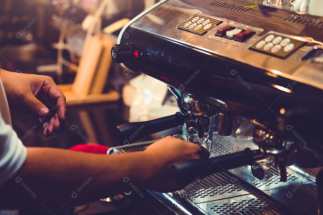 Close-up da mão profissional do barista masculino que faz a xícara de café.