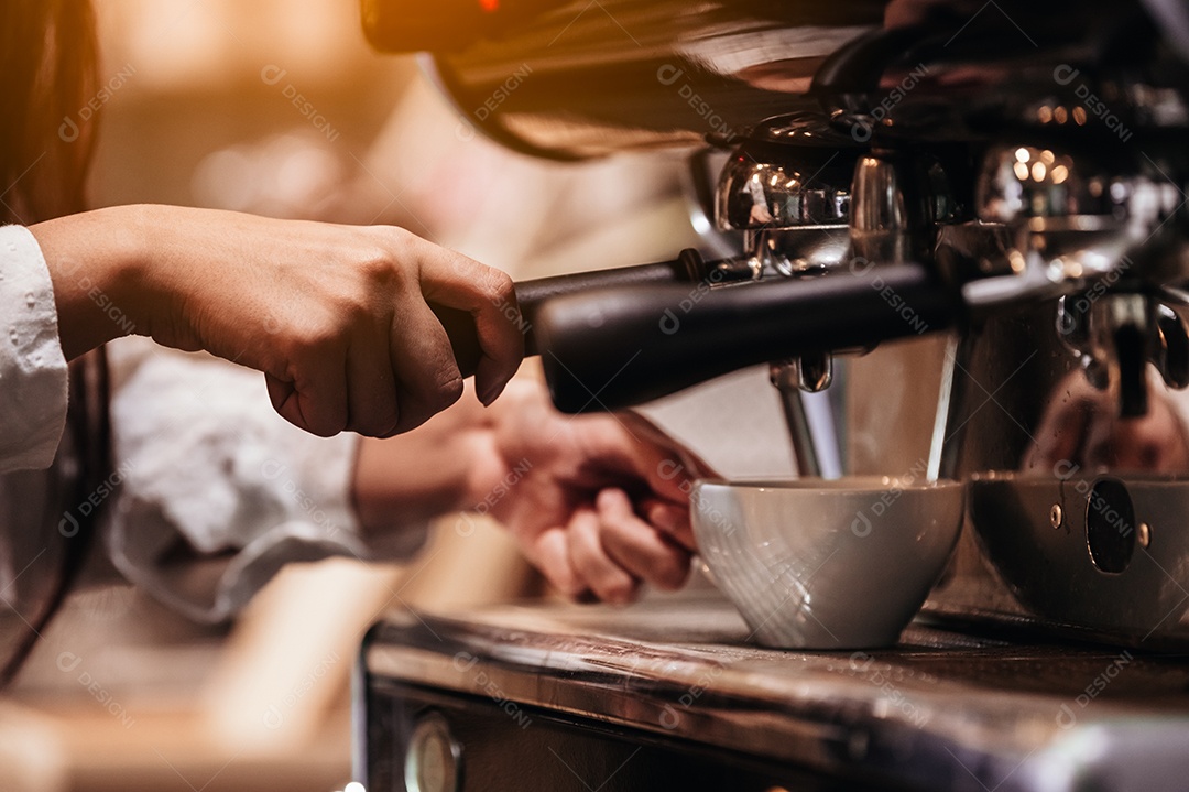 Detalhe da mão profissional de barista feminina fazendo café.