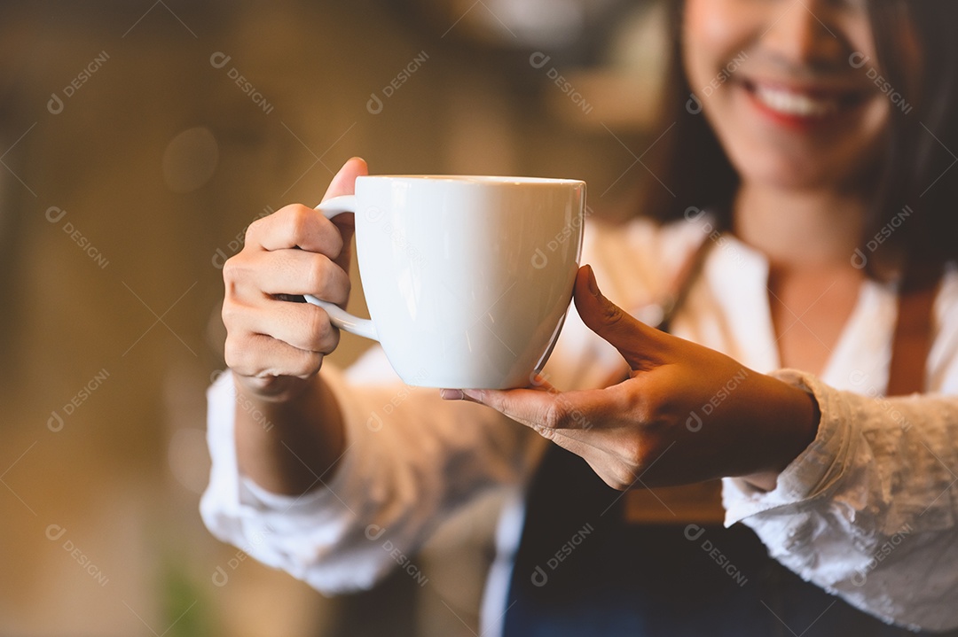 Aproximação da xícara de café branca com uma linda mulher asiática barista.