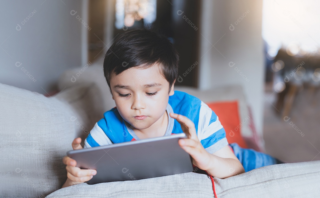 Menino usando tablet jogando jogo na internet
