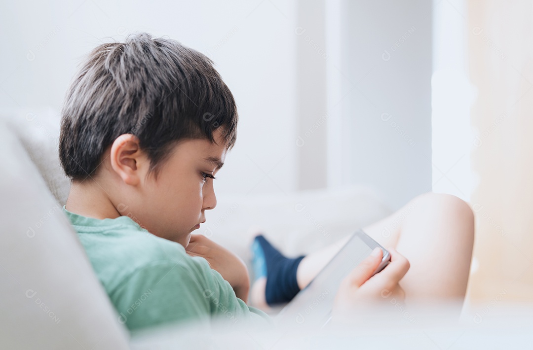 Menino caindo no sono enquanto usa tablet jogando na internet