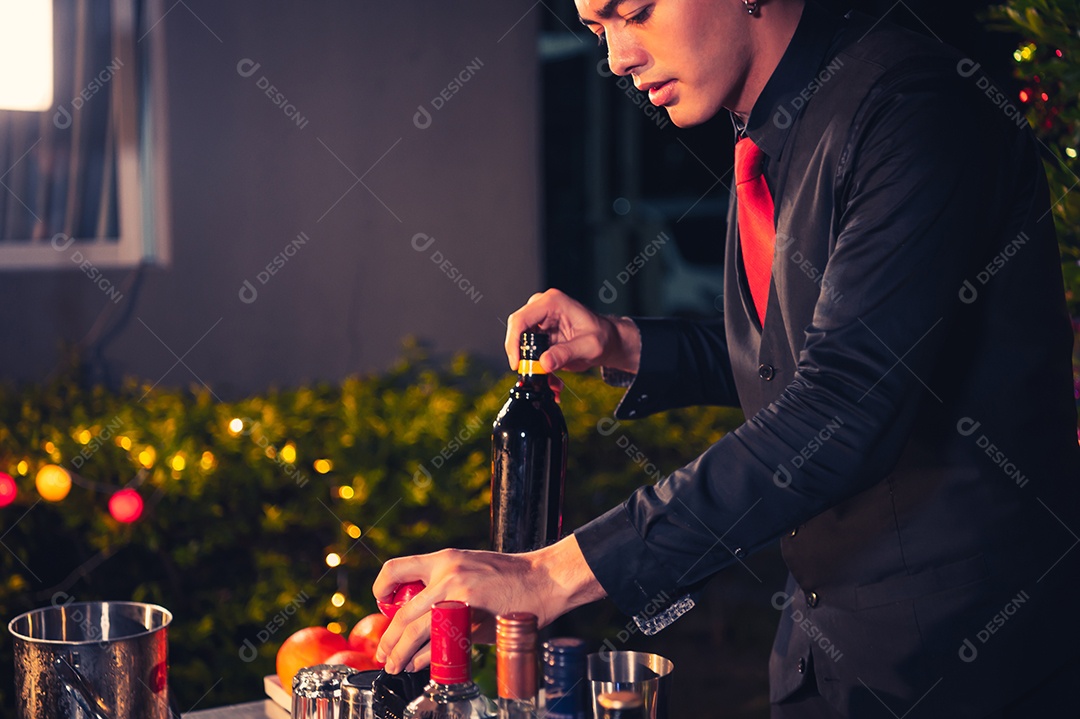 Barman profissional preparando coquetel de limonada de limão fresco em copo de vinho com gelo no bar noturno.
