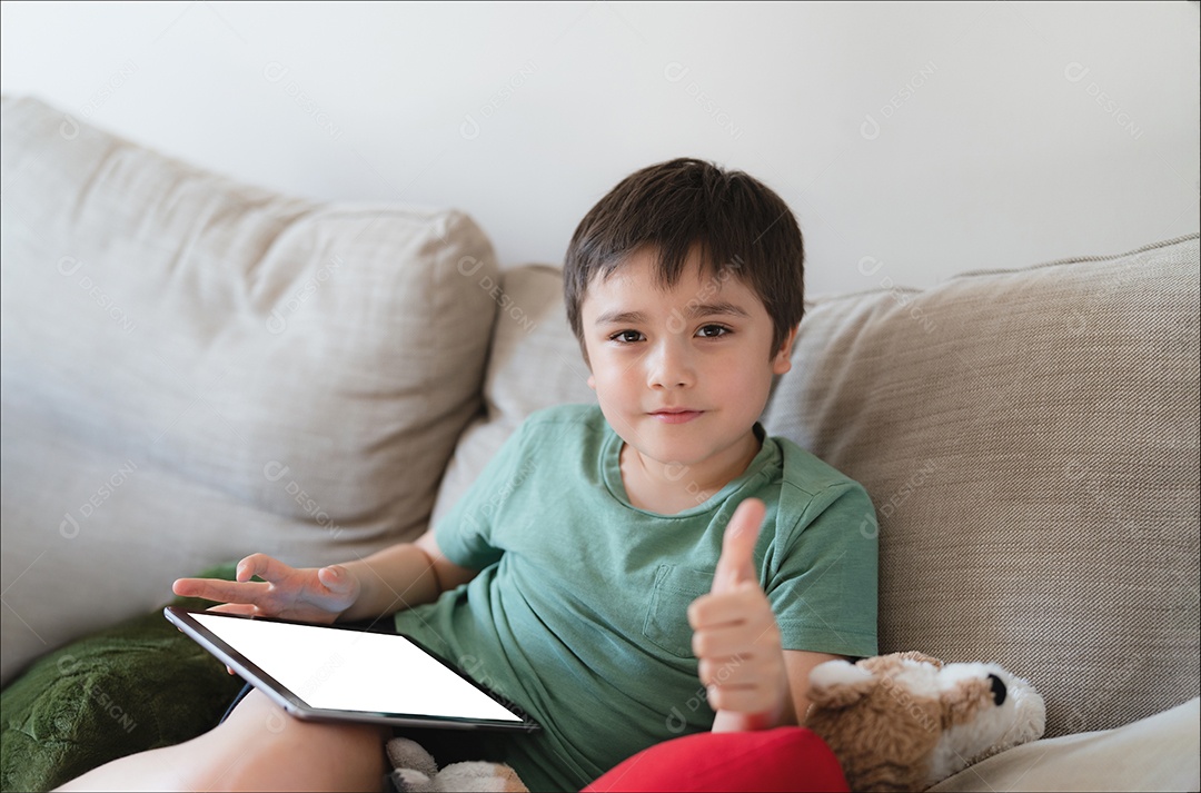 Menino usando tablet jogando jogo na internet com amigo