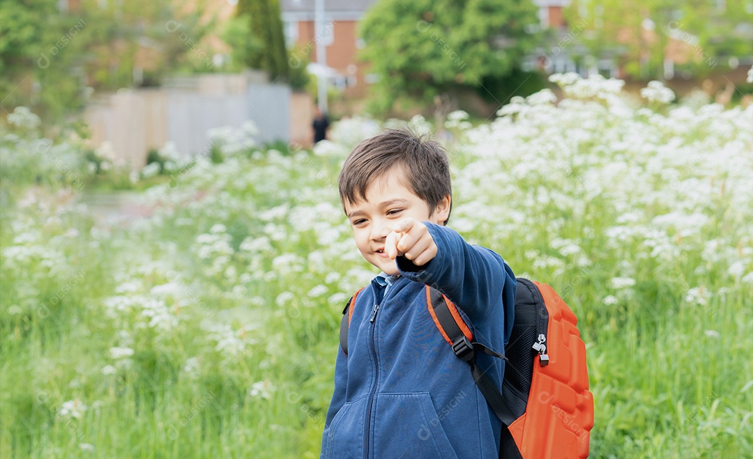 Garoto de escola feliz com mochila se divertindo enquanto caminhava para a escola pela manhã