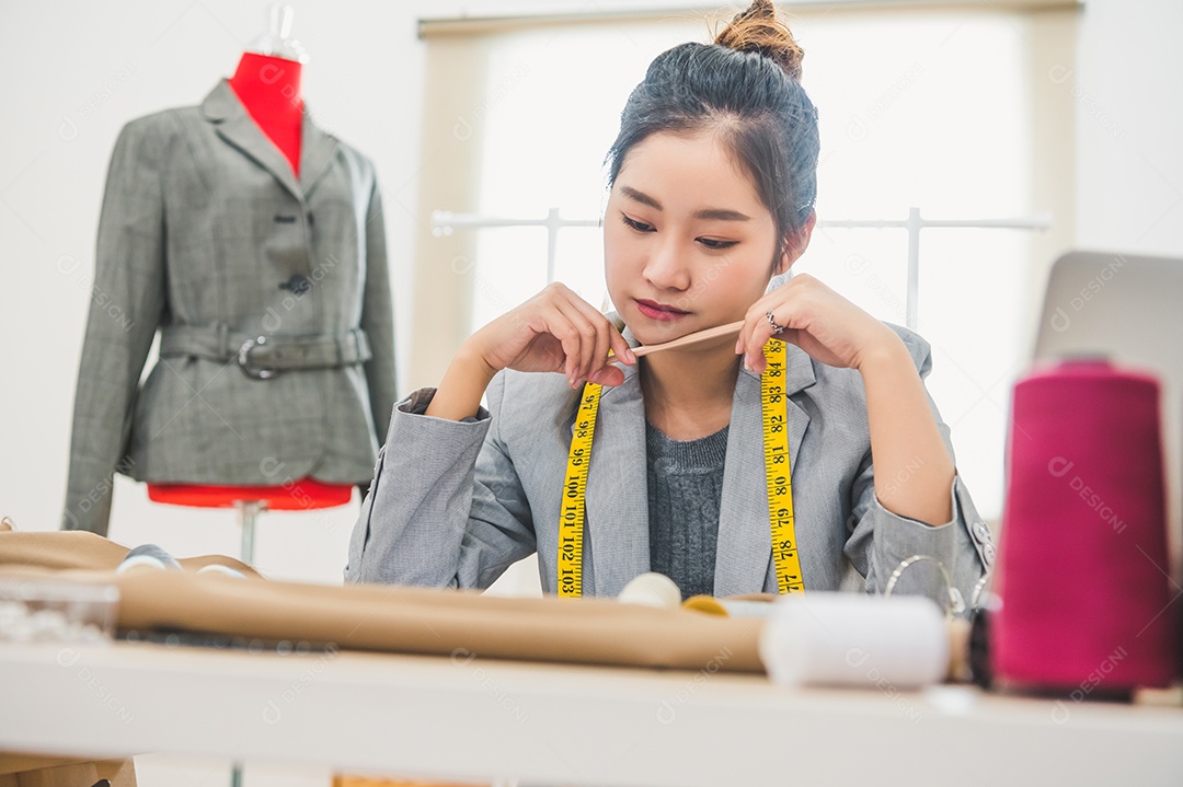 Atraente estilista asiática trabalhando na oficina de home office.