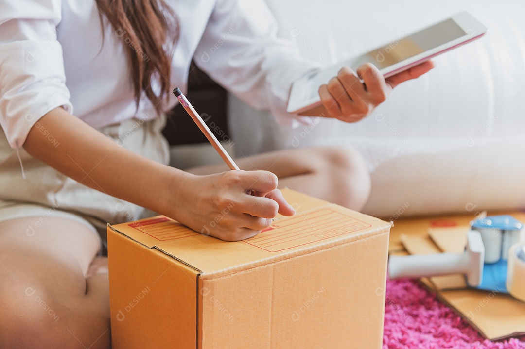 Close-up da mão de mulher de negócios asiáticos startup pequena empresa empresário PME armazém de distribuição com caixa de correio de encomendas.