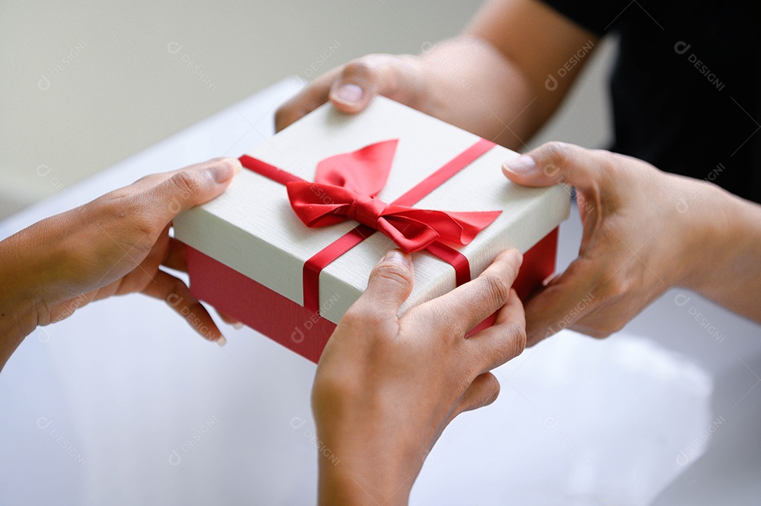 Close-up of hands giving gift box on Christmas Day and New Year.