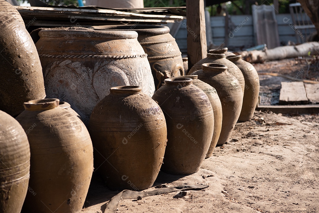 Frascos de barro tradicionais tailandeses antigos no chão ao ar livre. Grupo de vaso de padrão antigo clássico de dragão tailandês na província de Ratchaburi, na Tailândia. Conceito de fabricação industrial e artesanal.