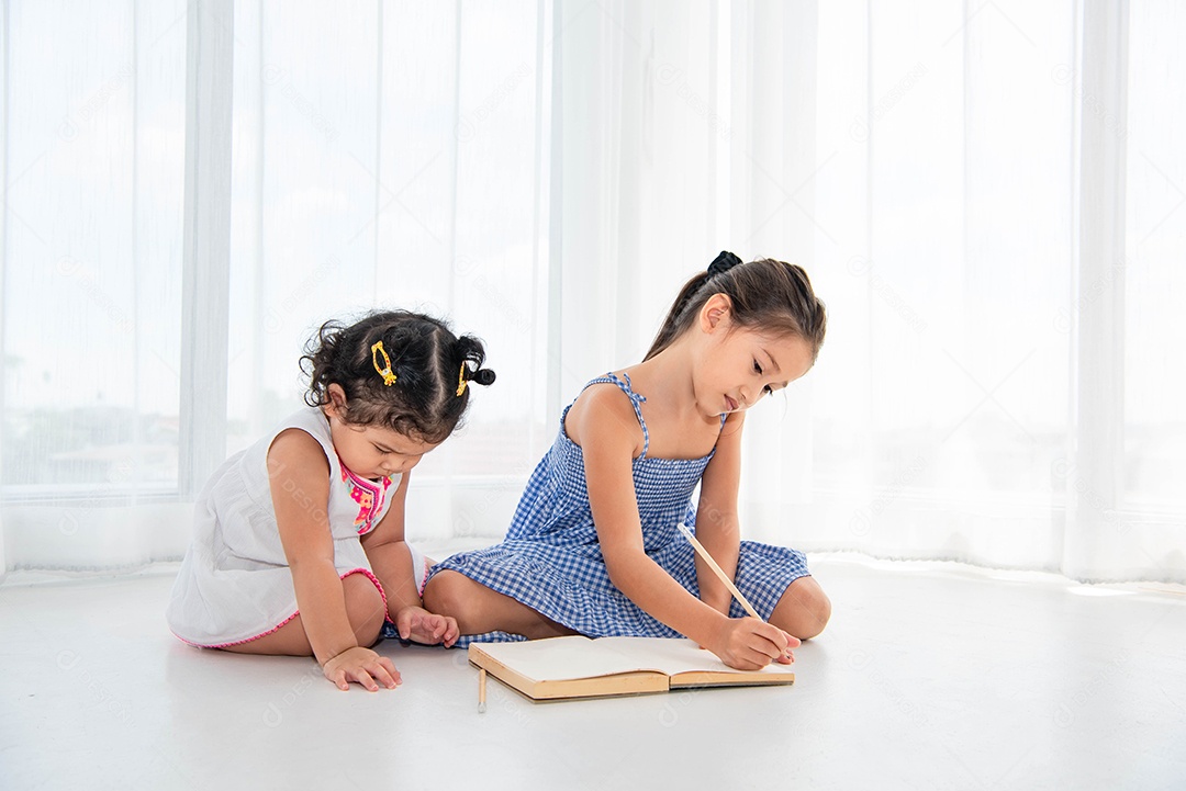 Duas irmãs felizes desenhando no caderno de esboços juntas em casa ou enfermeiras.