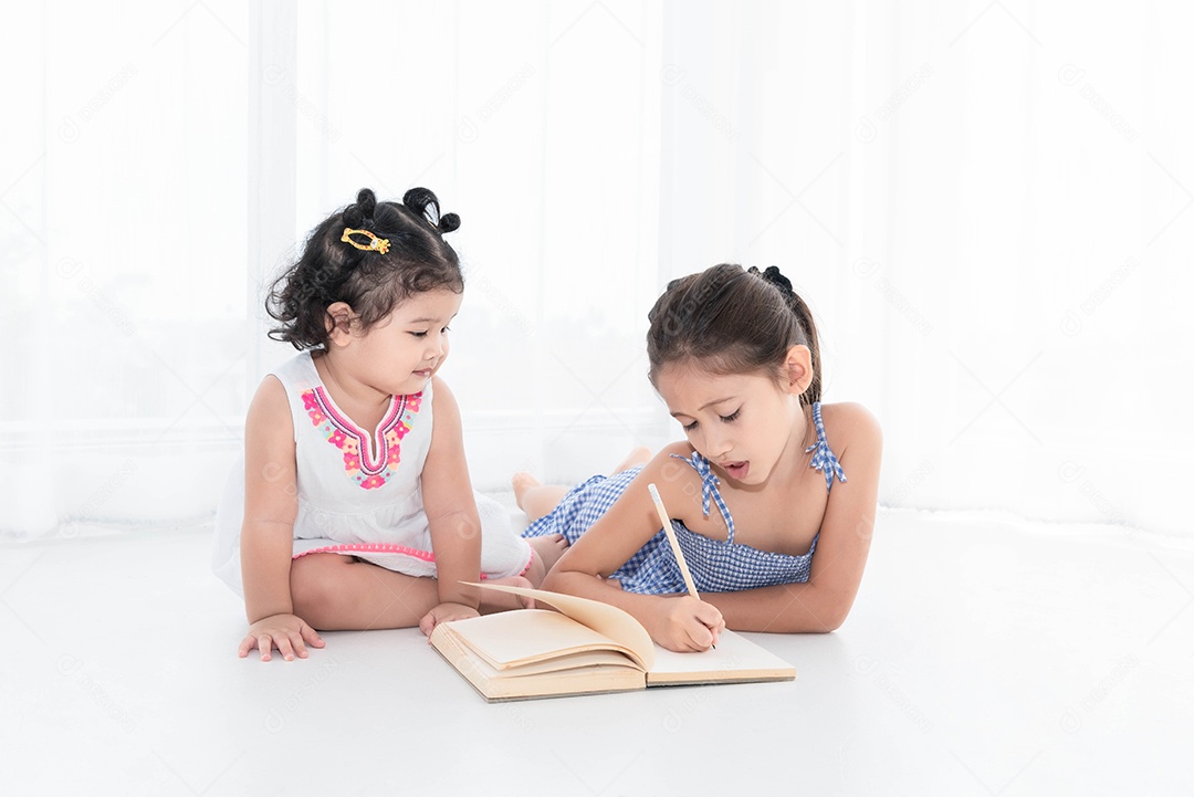 Duas irmãs felizes desenhando no caderno de esboços juntas em casa ou enfermeiras.