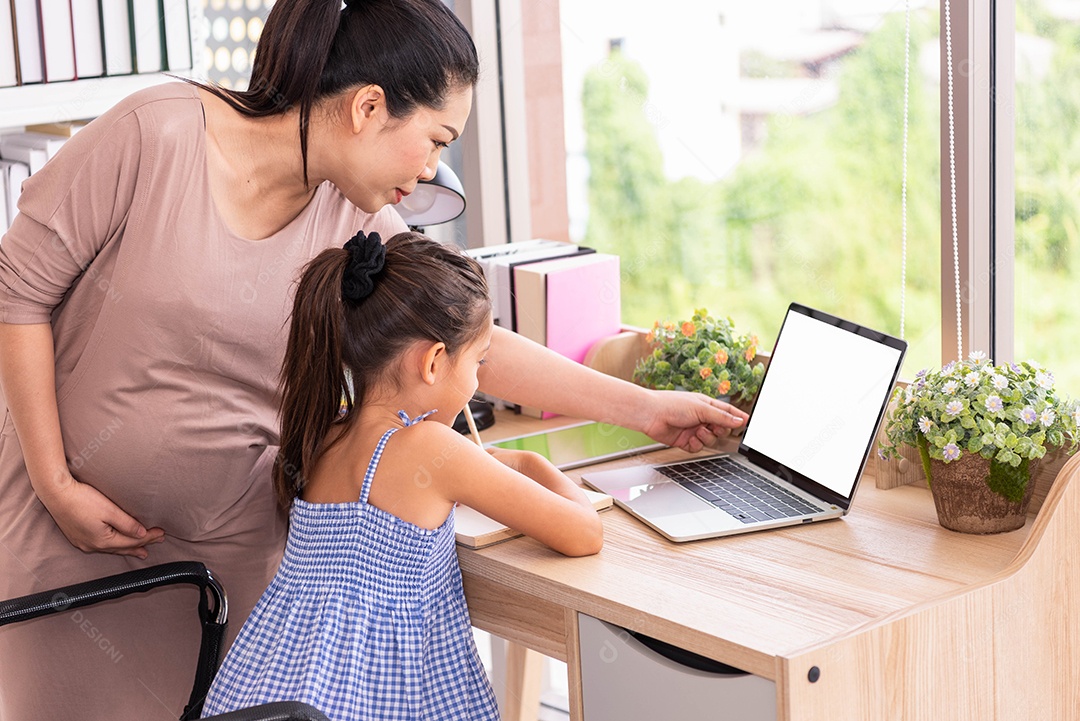 Cute daughter and her pregnant mother using blank white screen.