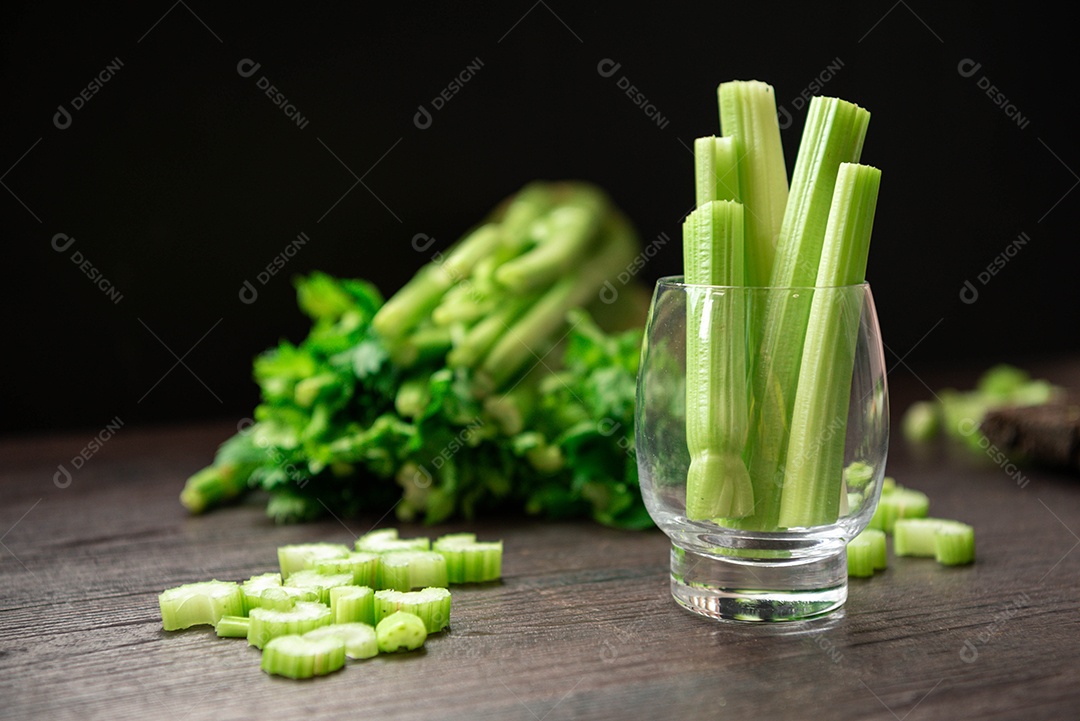 Bando de talo de aipo fresco na mesa de madeira com folhas preparadas.