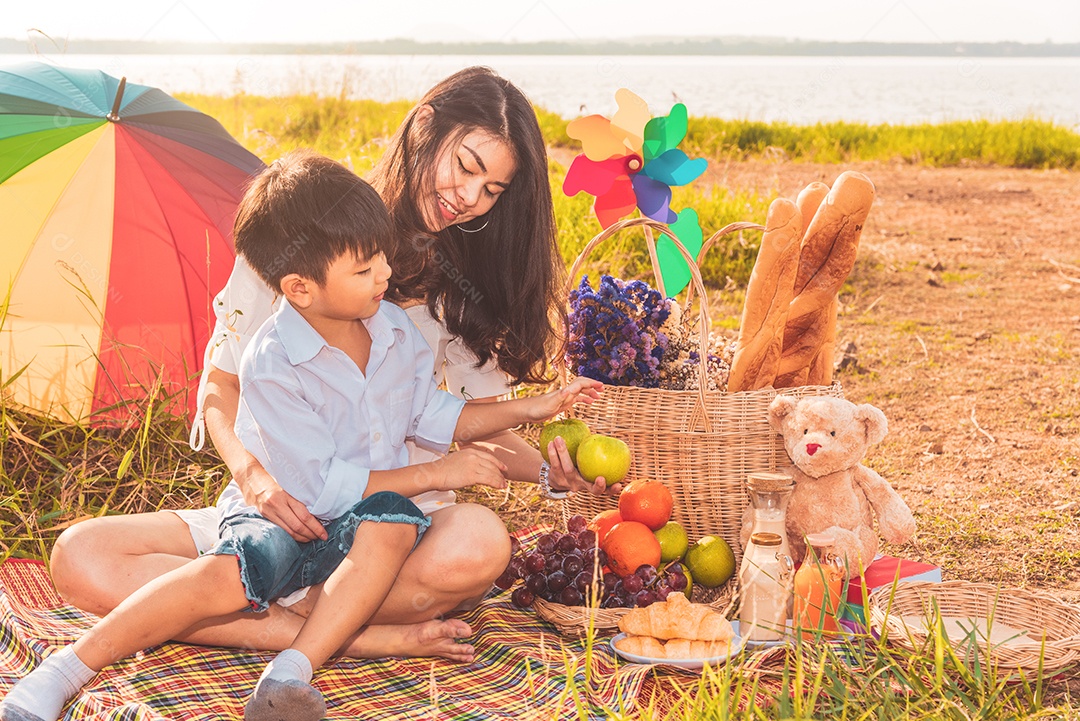 Linda mãe asiática e filho fazendo piquenique e no verão de Páscoa.