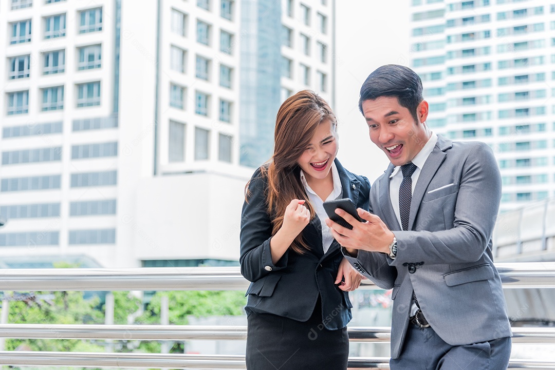 Empresário e sua secretária ficam surpresos ao olhar para o smartphone.