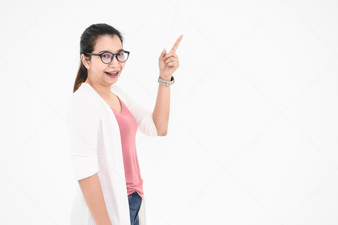 Mulher asiática posando e apontando o dedo no espaço em branco.