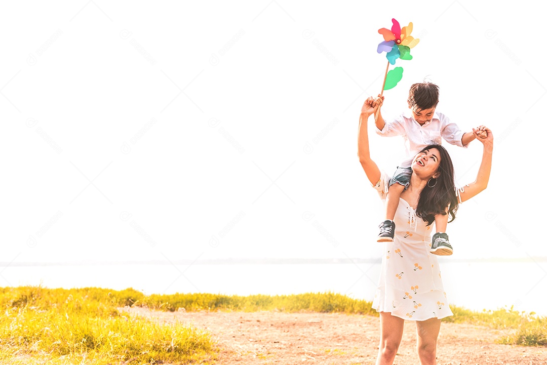 Garotinho asiático cavalgando em sua mãe superpoderosa em prado.
