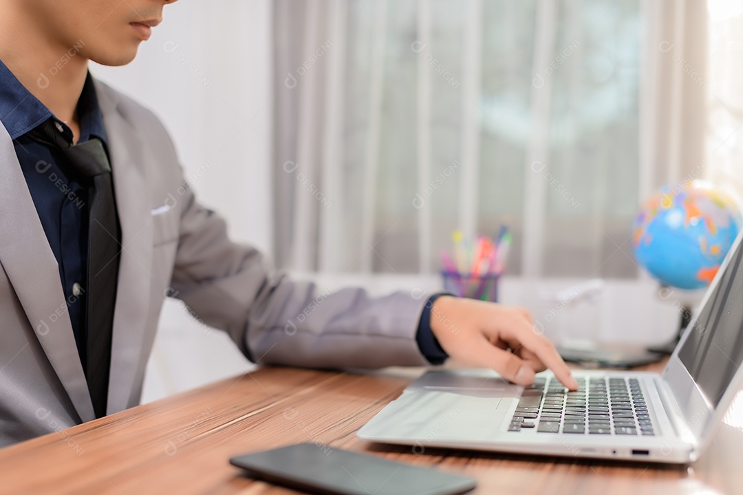 Homem de negócios que usa o computador portátil no escritório