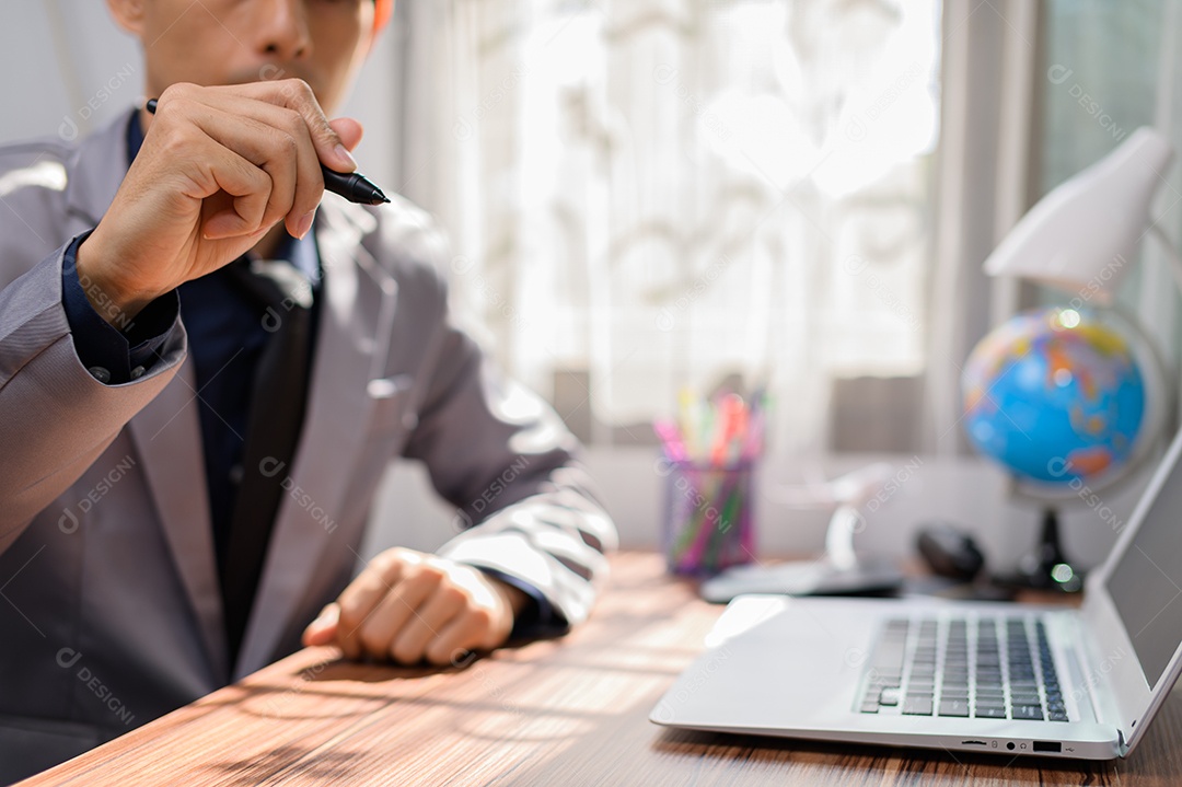 Empresário trabalhando na frente de um notebook em uma mesa