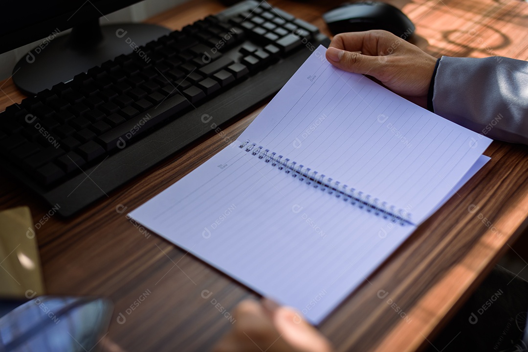 Empresário lendo e escrevendo documentos no trabalho