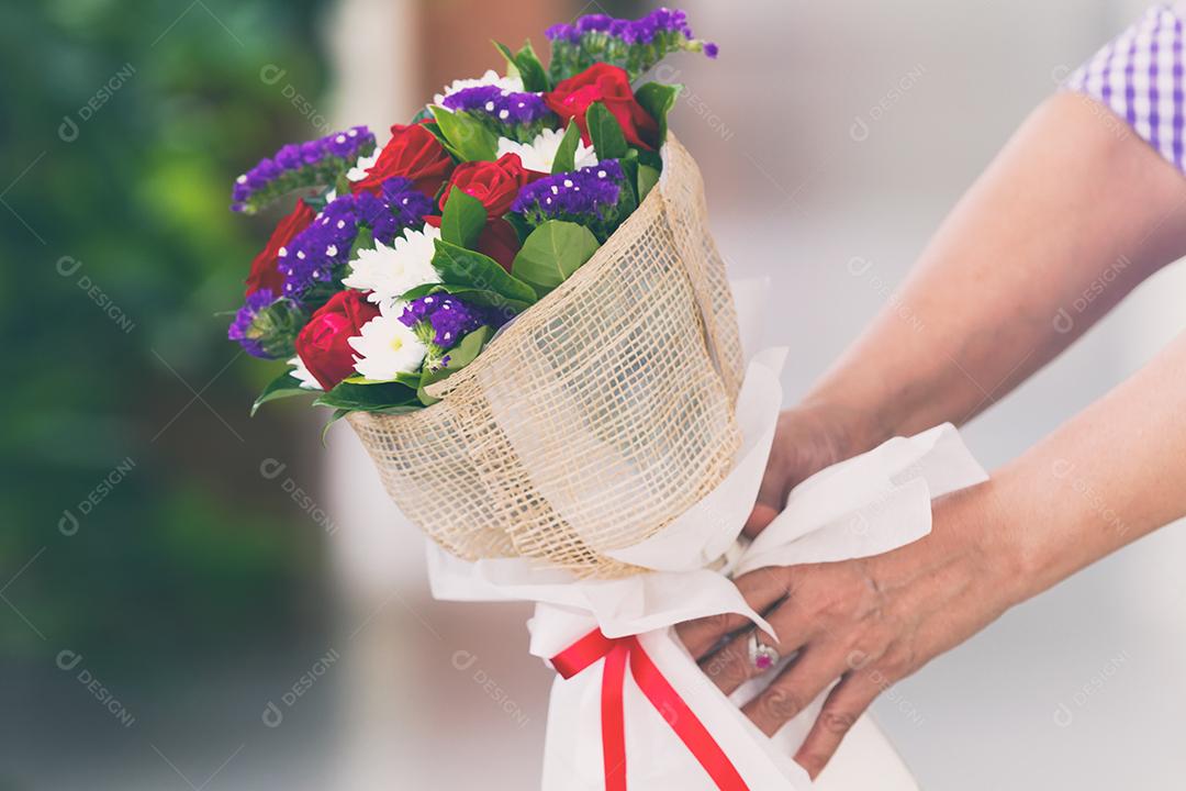 Mulher segurando um buquê de rosas na mão para o dia dos namorados