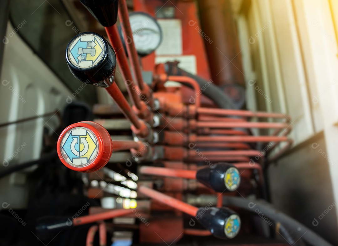 Tubos hidráulicos, acessórios e alavancas no painel de controle do mecanismo de elevação.