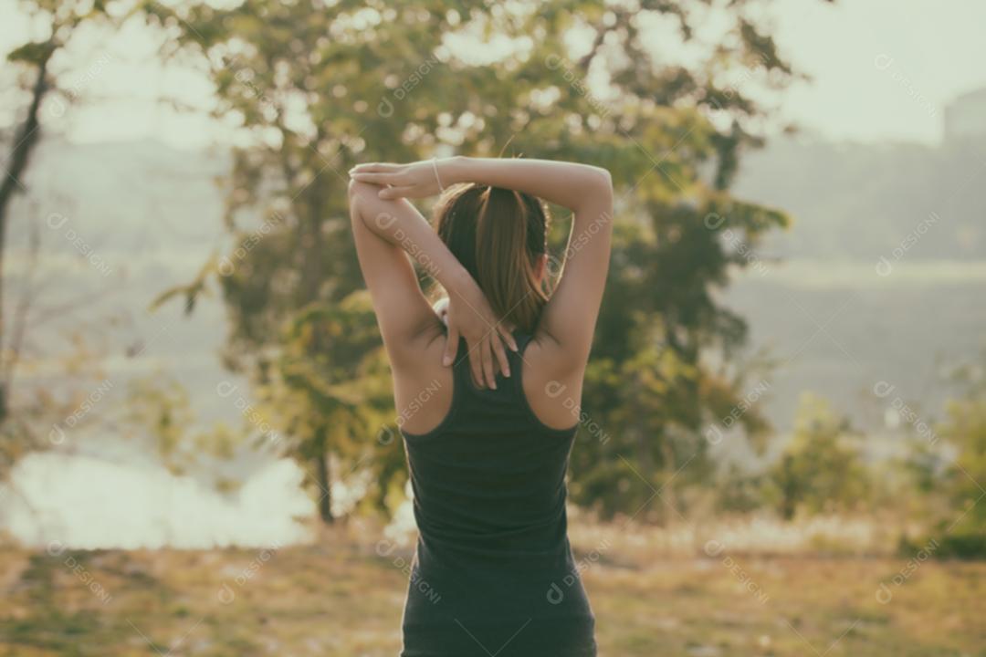 Mulher atlética asiática aquecendo e jovem atleta sentada em um exercício e alongamento em um parque antes do corredor ao ar livre, conceito de estilo de vida saudável, foco suave