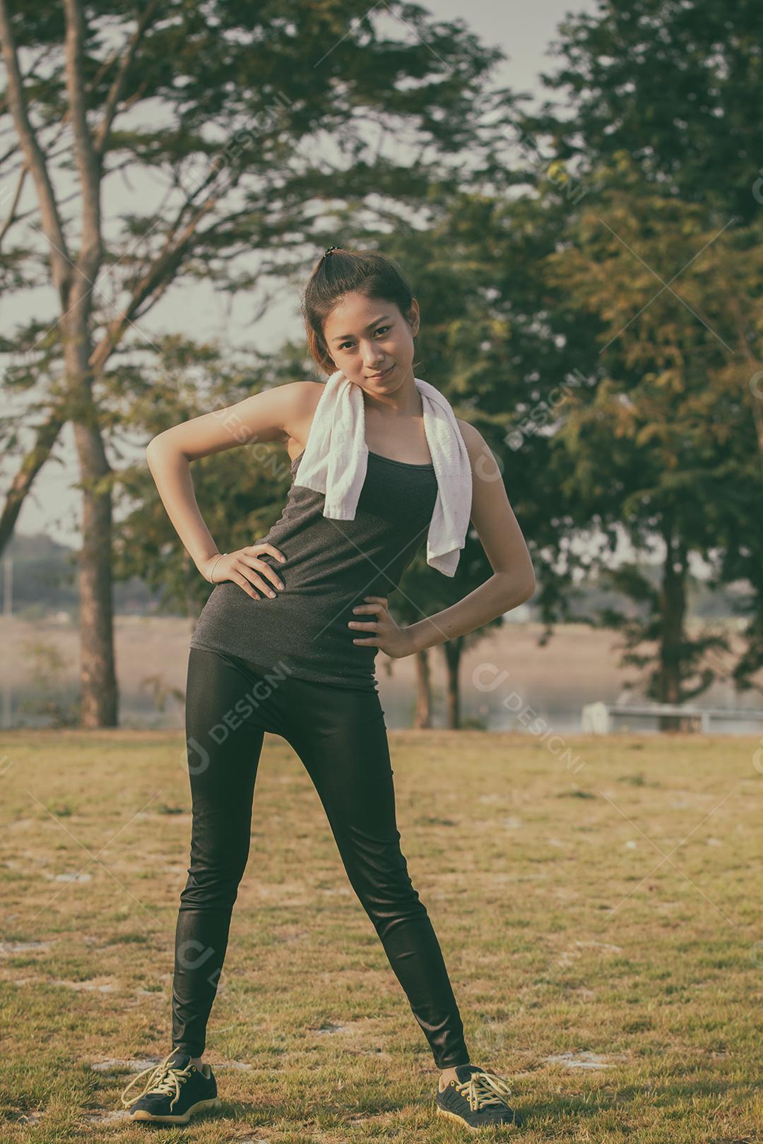 Mulher atlética asiática aquecendo e jovem atleta sentada em um exercício e alongamento em um parque antes do corredor ao ar livre, conceito de estilo de vida saudável, foco suave