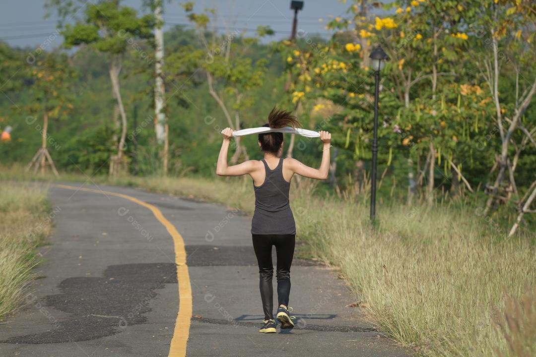 Foco embaçado e suave da mulher em execução. Corredor feminino correndo durante ao ar livre na estrada.
