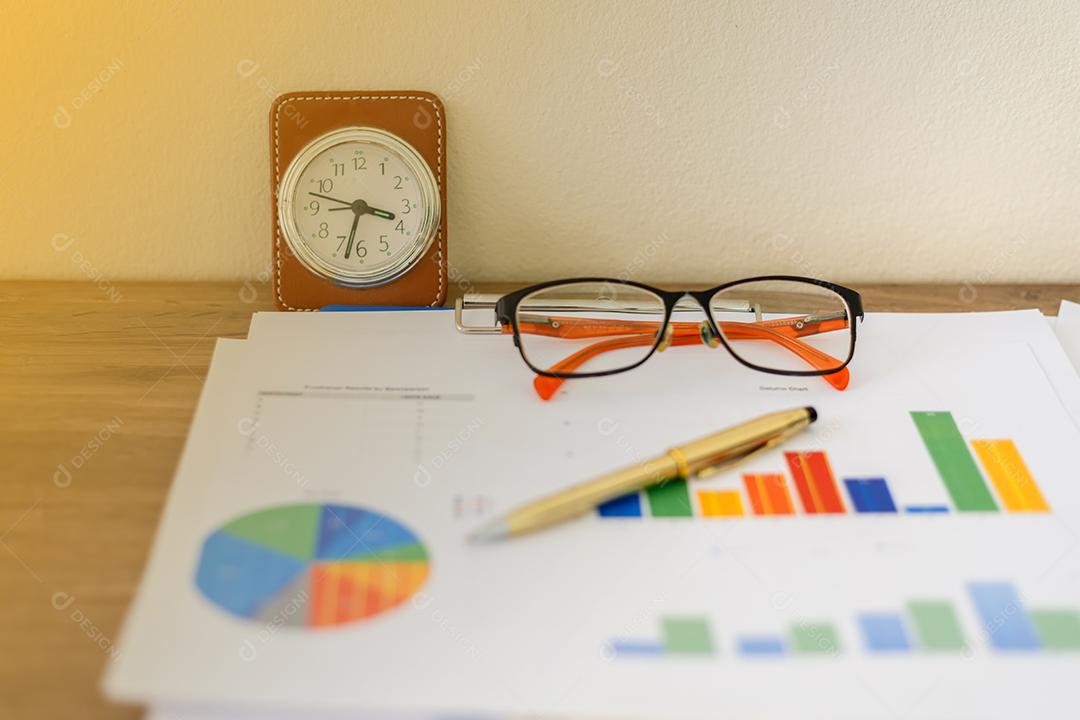 Conceito de negócios de gráficos de trabalho e análise de escritório e relógio na mesa