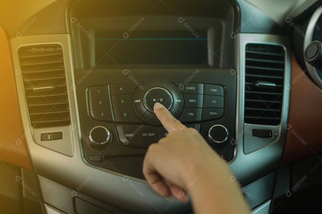 As mulheres pressionam o botão no rádio do carro