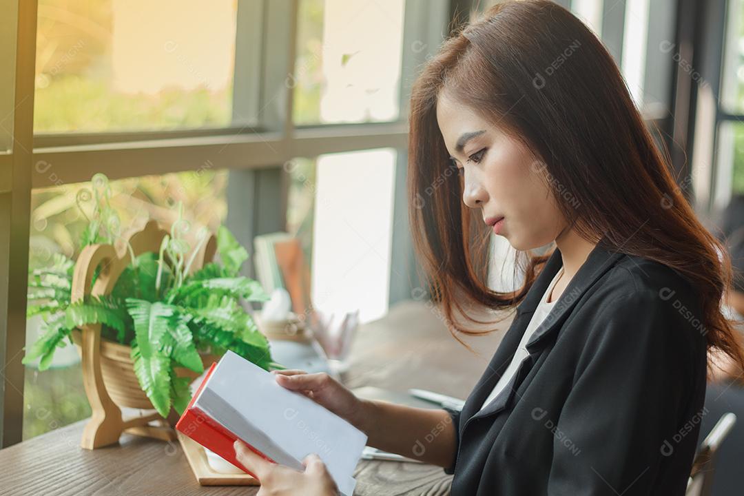 Mulher asiática lendo um livro para relaxar.