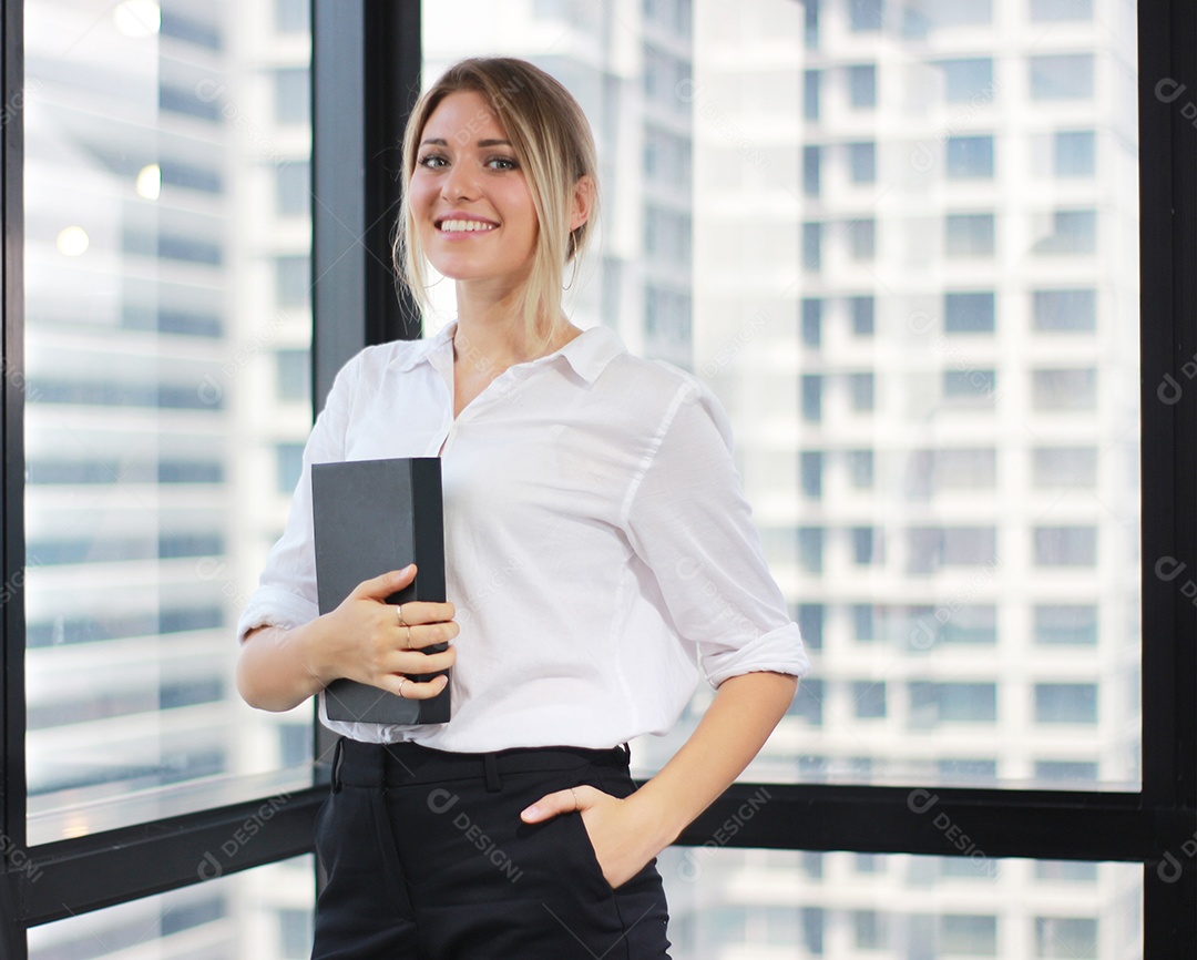 Retrato de uma empresária segurando um notebook no escritório moderno