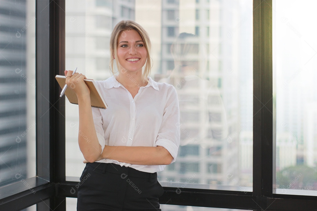 Retrato de uma empresária segurando um notebook no escritório moderno