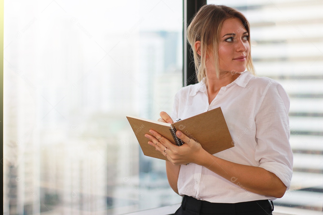 Retrato de uma empresária segurando um notebook no escritório moderno