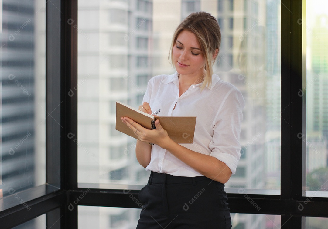 Retrato de uma empresária segurando um notebook no escritório moderno