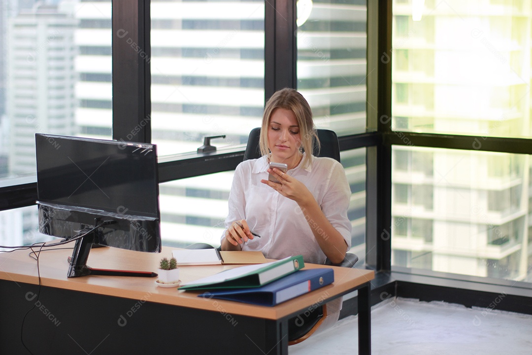 Retrato de uma mulher de negócios usando telefone celular em um escritório iluminado