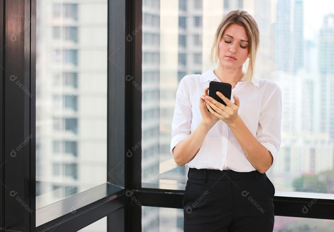 Retrato de uma mulher de negócios usando telefone celular em um escritório iluminado