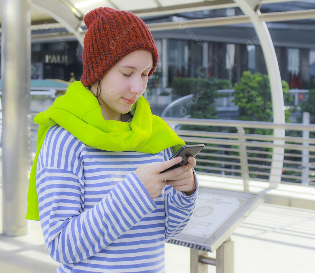 Jovem linda garota em dia de inverno com telefone inteligente