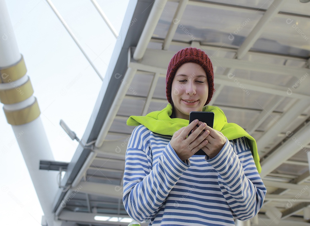 Jovem linda garota em dia de inverno com telefone inteligente