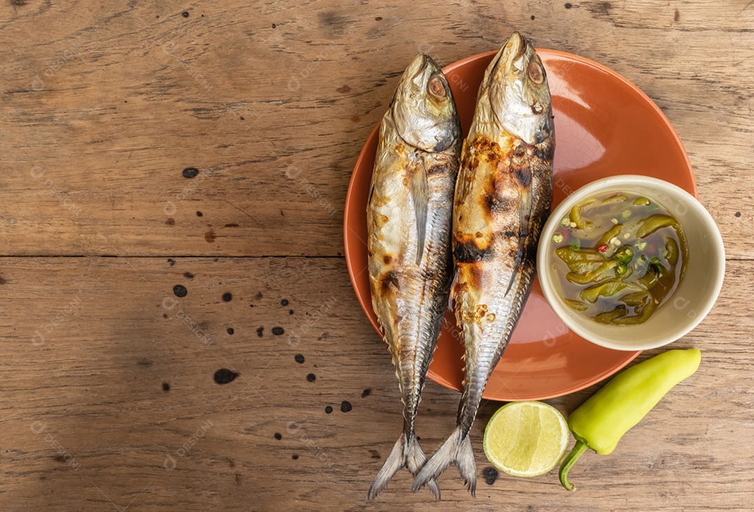 Peixe grelhado no prato e molho de frutos do mar picante picante