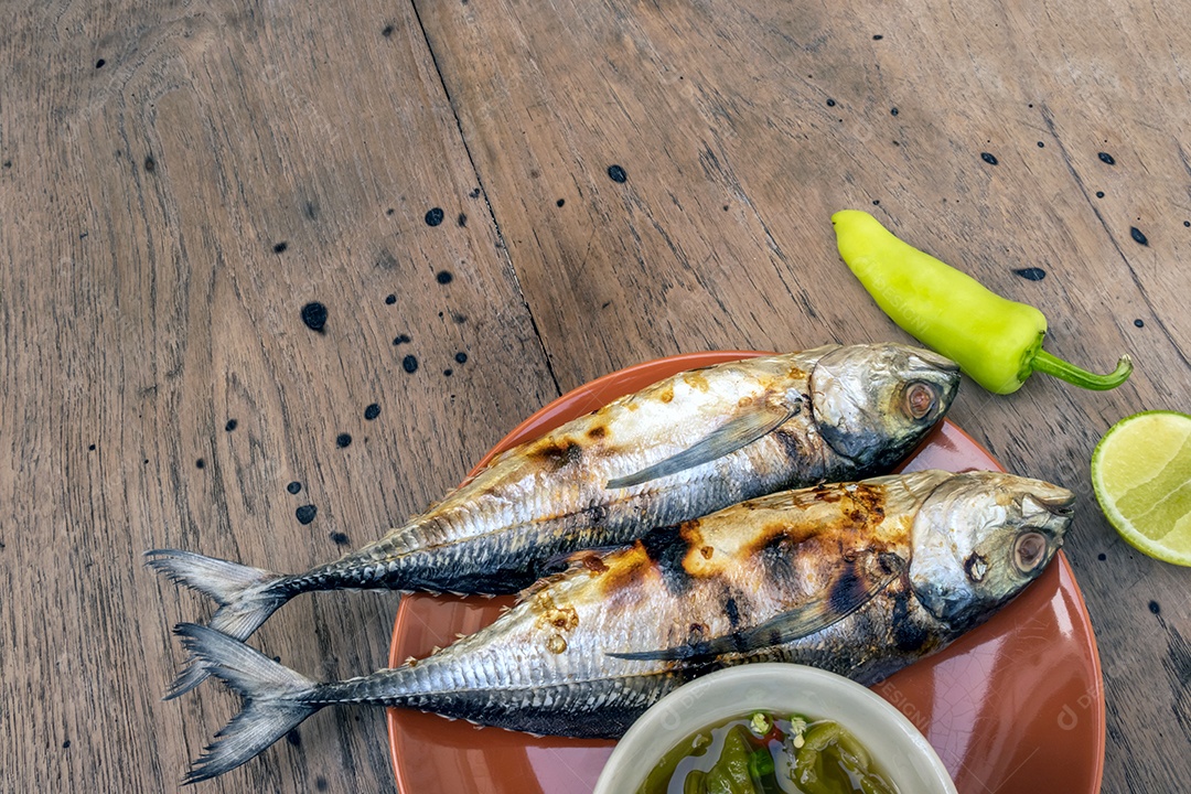 Peixe grelhado no prato e molho de frutos do mar picante picante