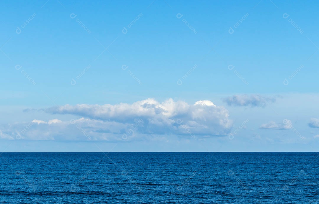 Mar calmo e fundo de céu azul.
