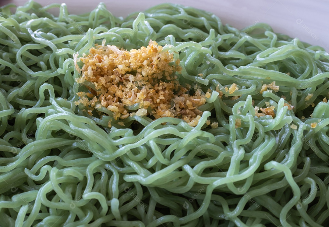 Macarrão verde polvilhado por cima com alho frito