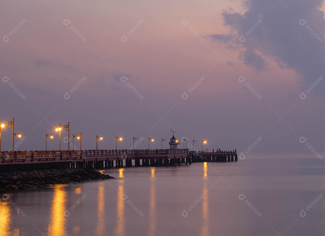 Fundo da ponte, esticado no mar, crepúsculo da manhã, cores bonitas, papéis de parede do céu e farol. Uma luz refletida no mar