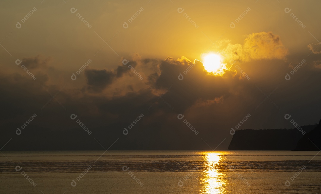 Nascer do sol colorido da praia do oceano com céu azul profundo e raios de sol