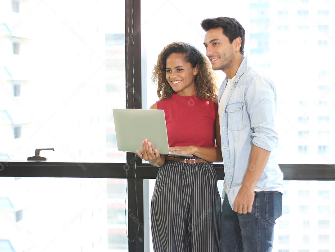 Retrato de jovem casal usando laptop para enviar uma mensagem para contato